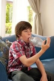 Child holding a asthma medication spacer